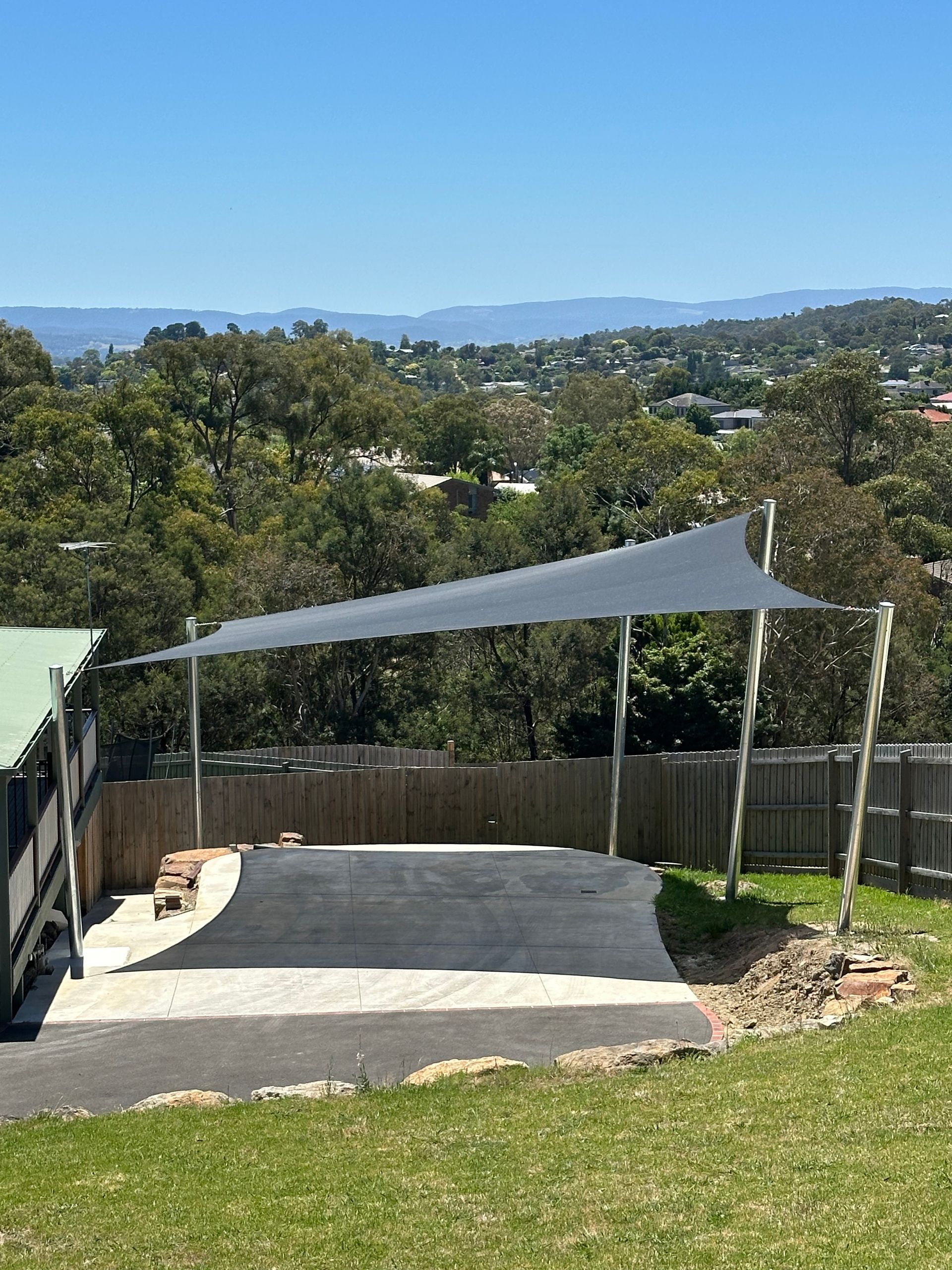 Weather-resistant black shade sail covering caravan parking bay in Lilydale, providing sun, water, and hail protection with reinforced support structure for long-term outdoor storage