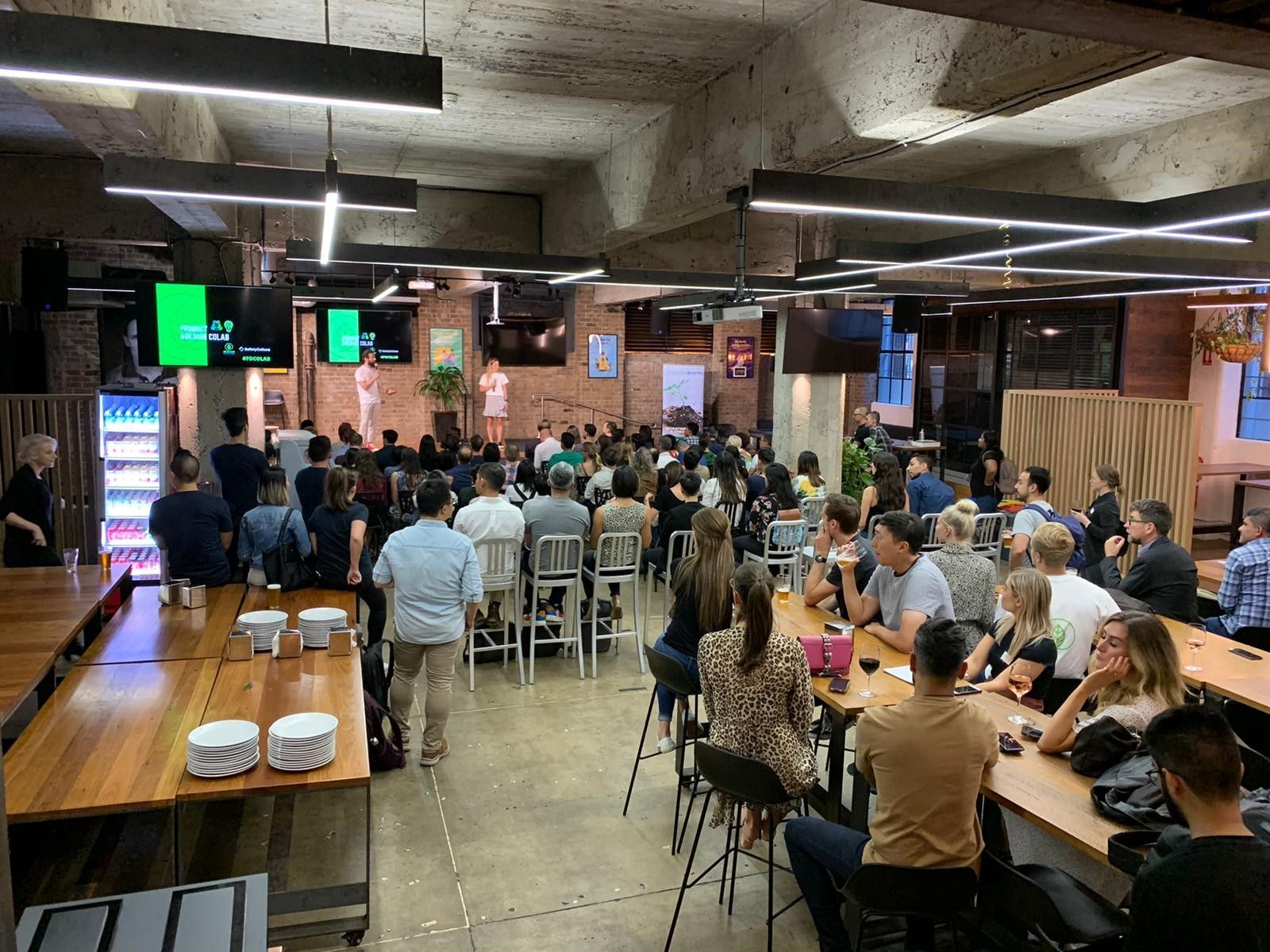 A large group of people are sitting at tables in a restaurant.