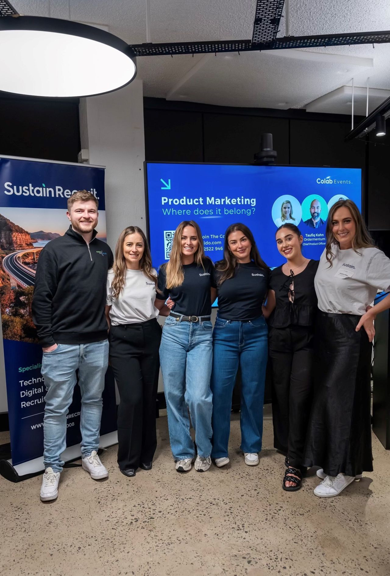 A group of people are posing for a picture in a room.