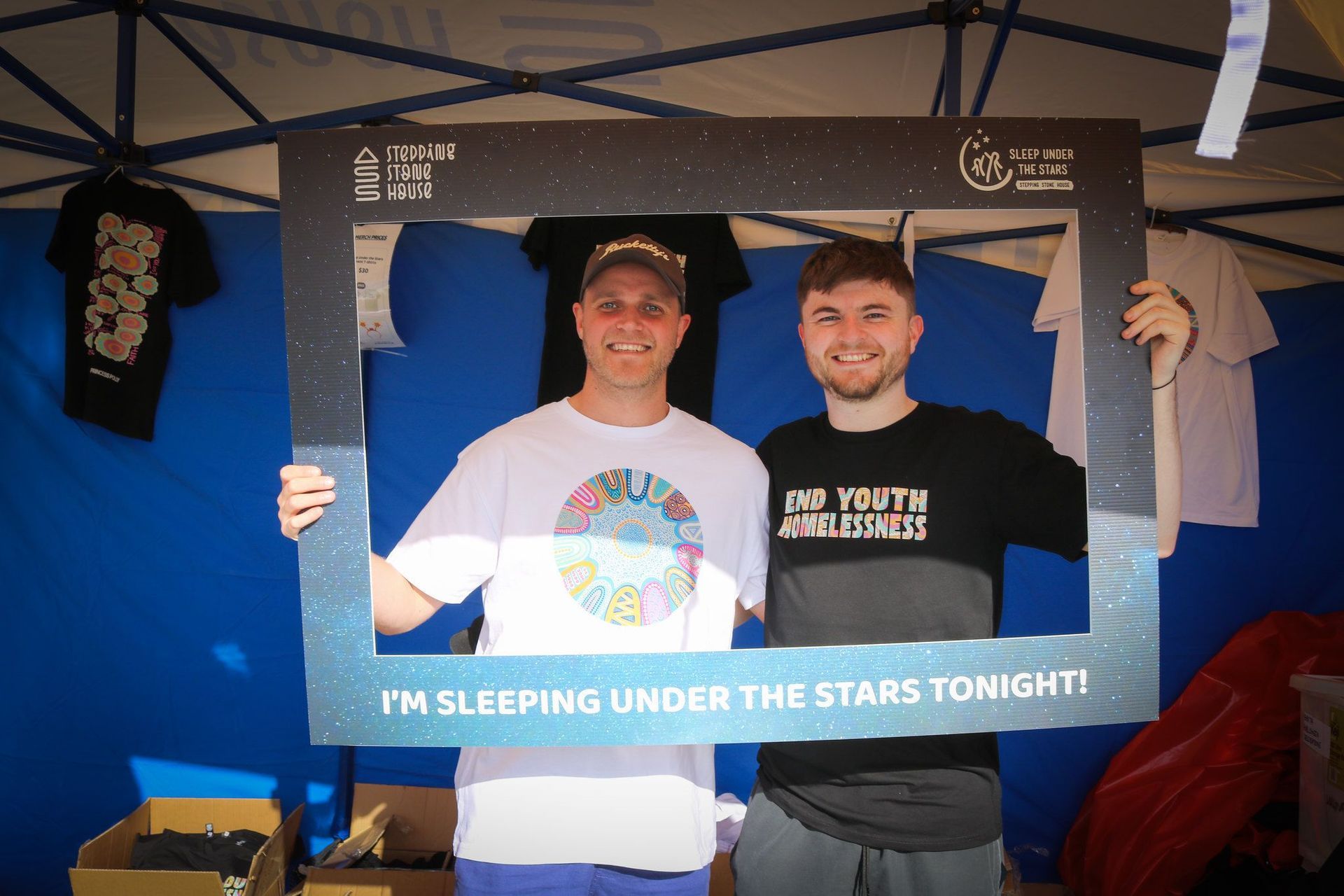 Two men holding a picture frame that says i 'm sleeping under the stars tonight