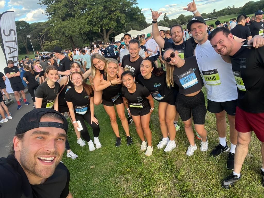 A group of people are posing for a picture in a park.