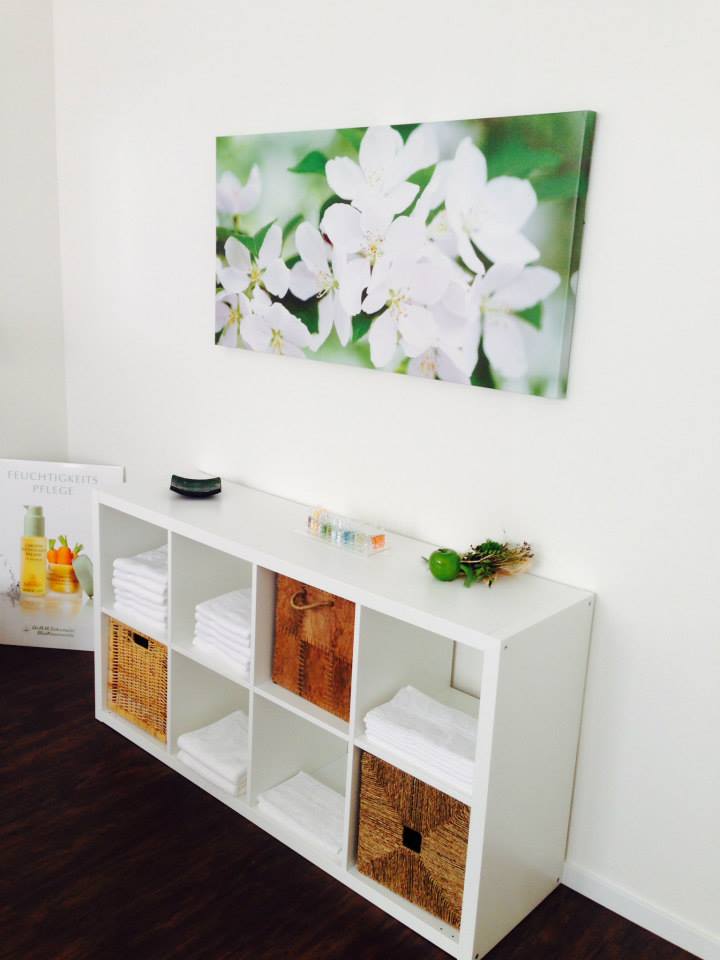 Ein Bild mit weißen Blumen hängt über einem weißen Regal