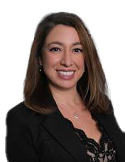 A woman wearing a black shirt and a necklace is smiling.