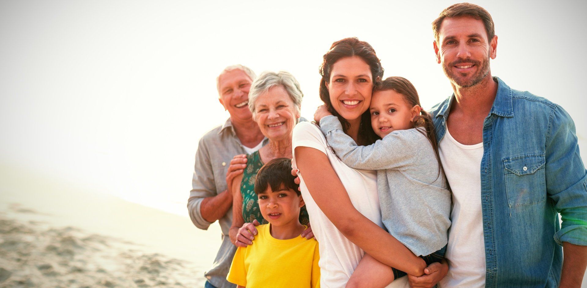 A family is posing for a picture on the beach.