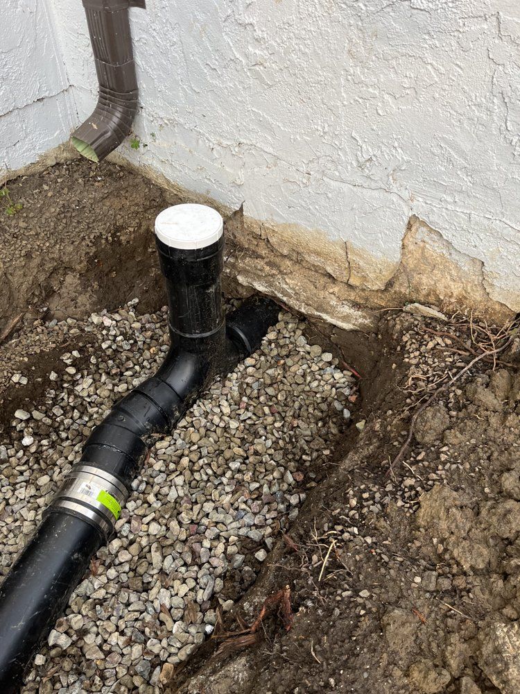 A drain pipe is being installed in a hole in the ground.