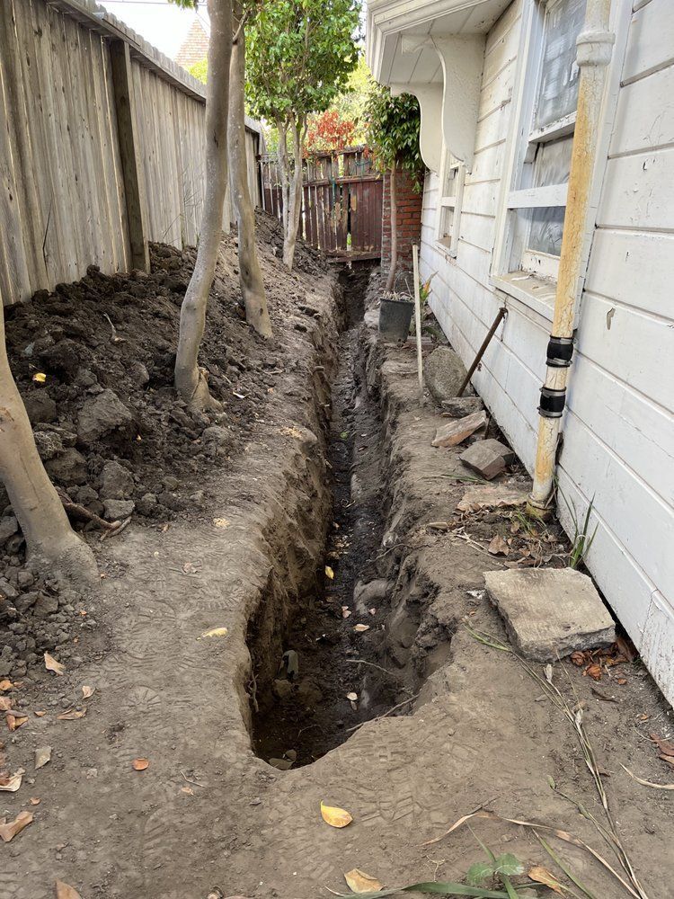 A large hole in the ground in front of a house