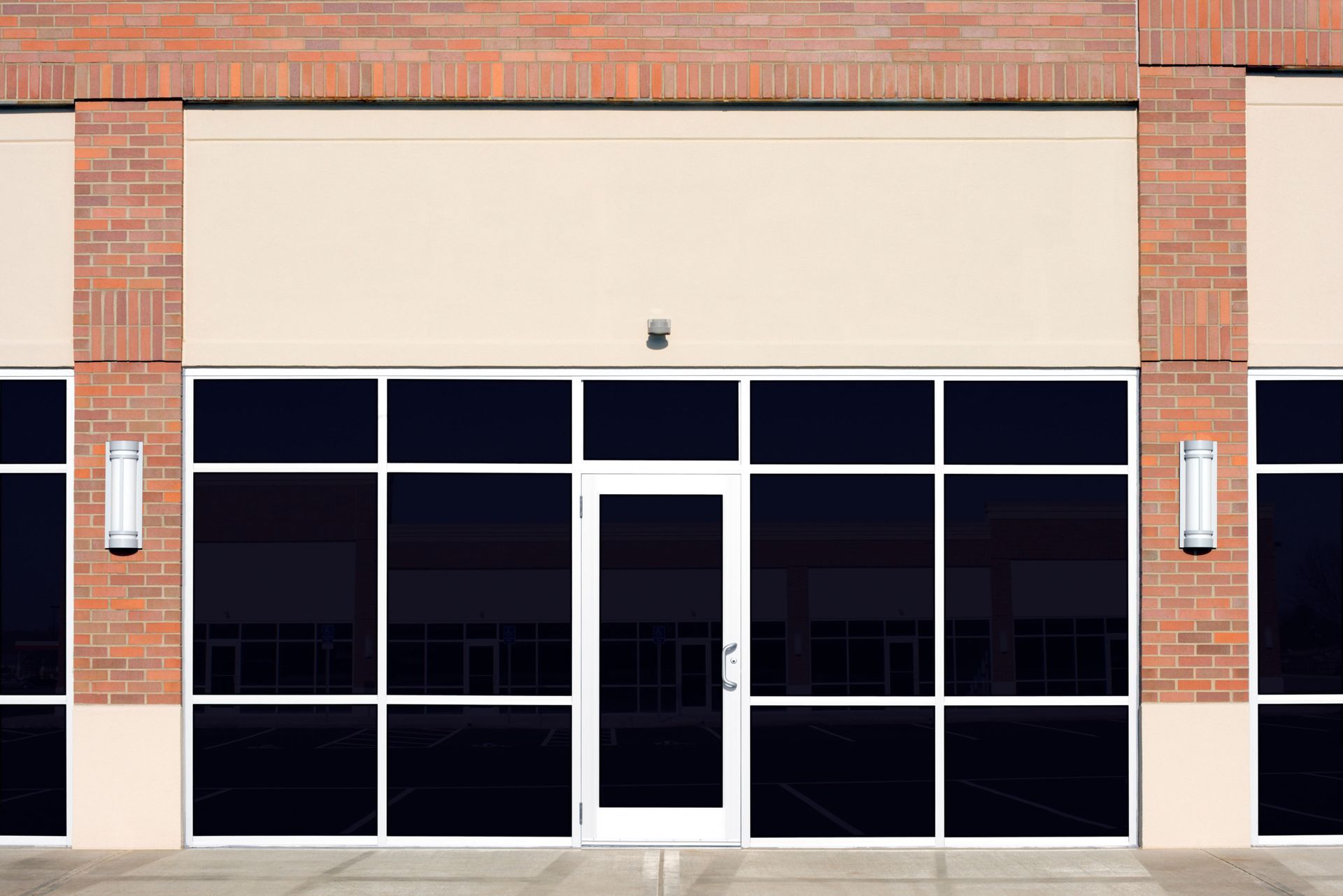 Empty storefront with dark windows and brick accents.