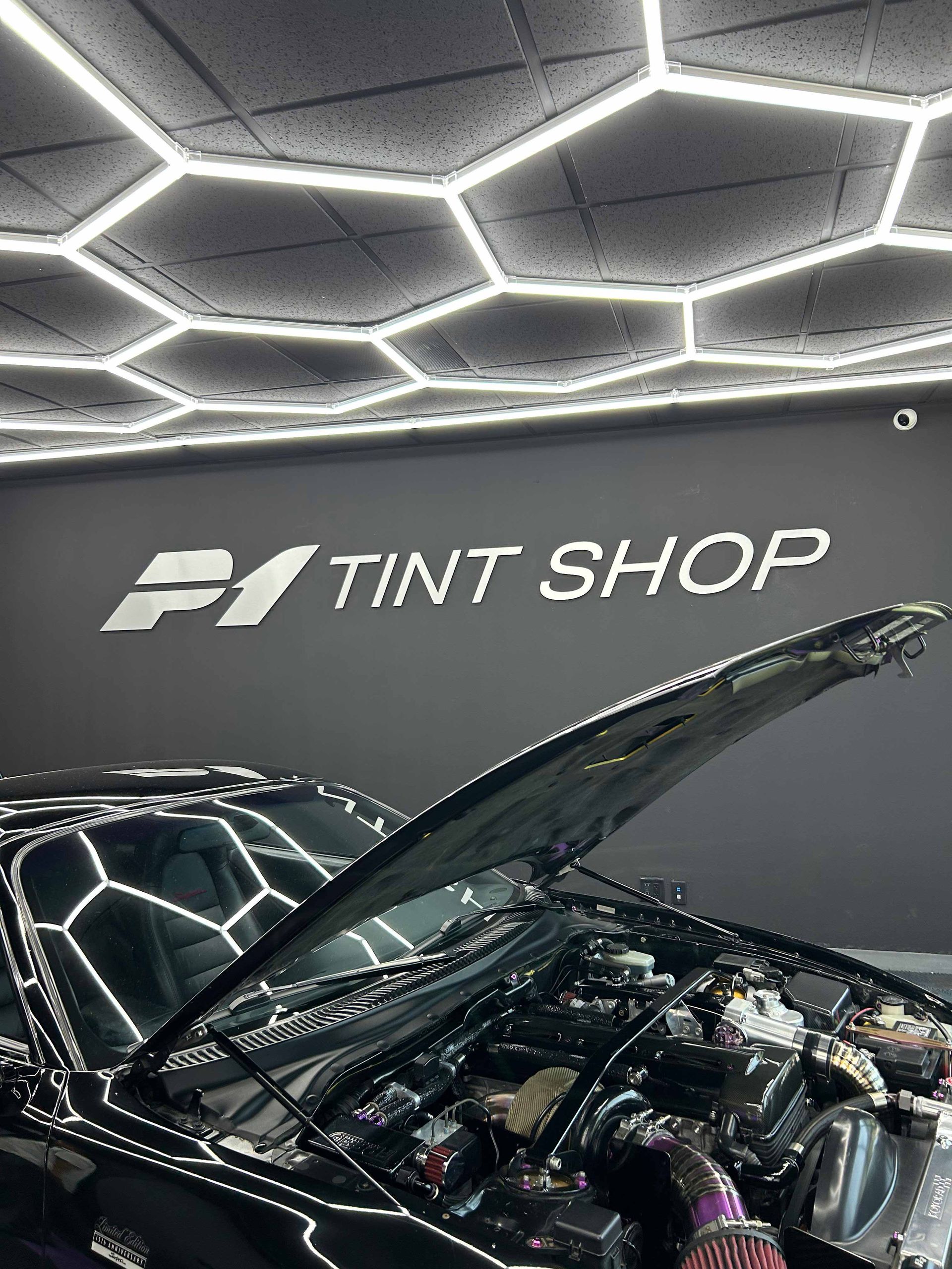 Car with open hood in a shop with the sign