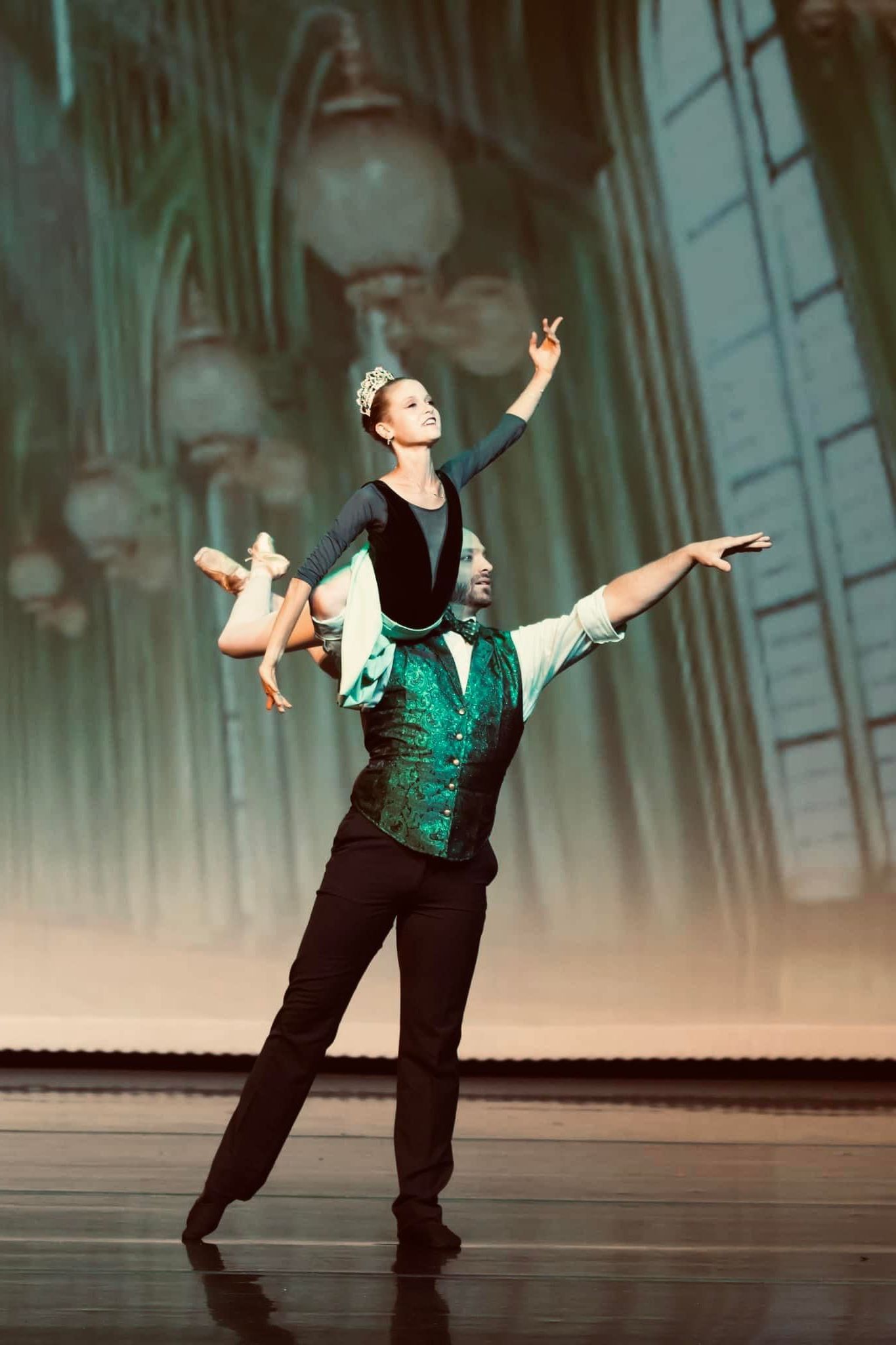 A man is carrying a woman on his shoulders on a stage.