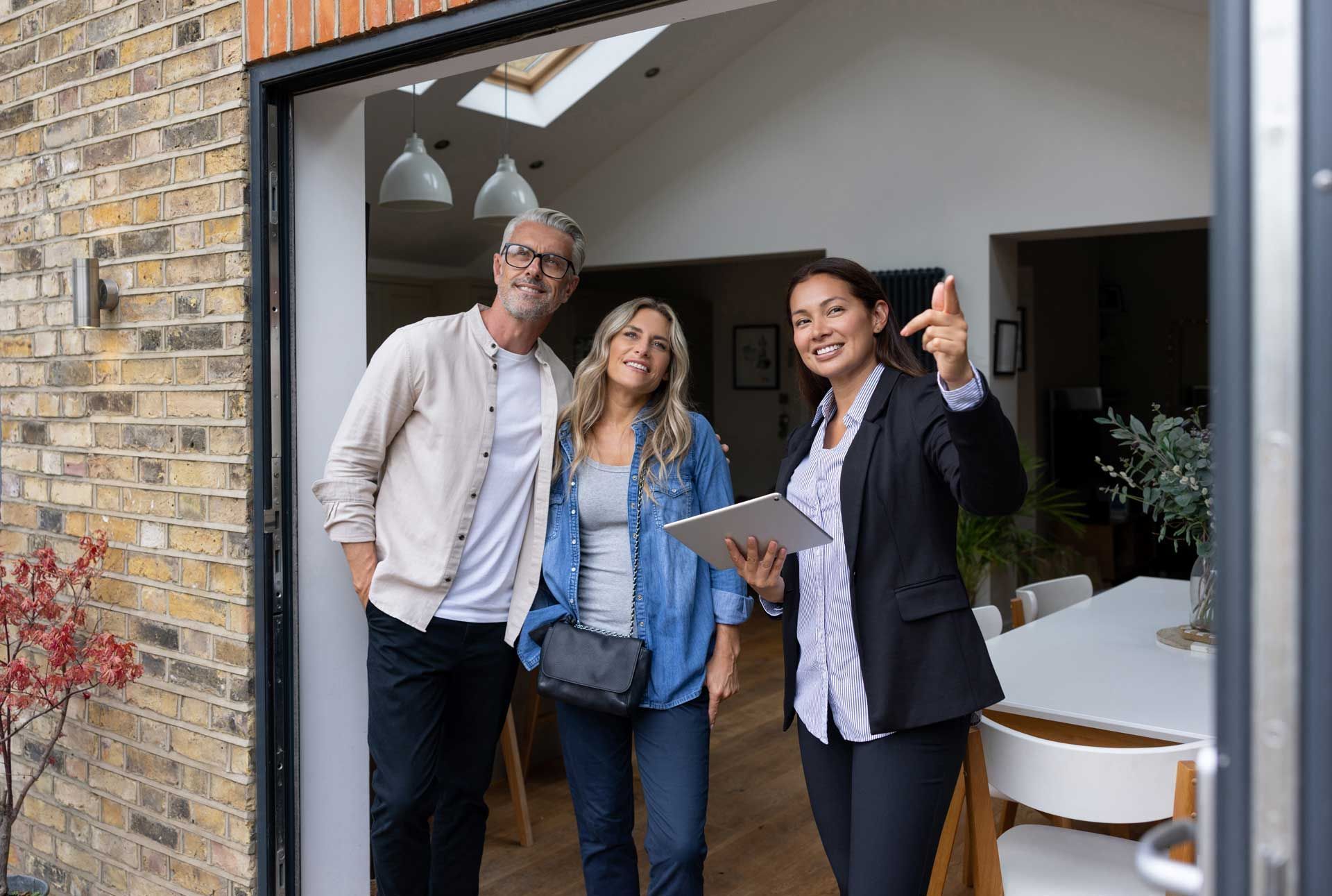 A real estate agent is showing a couple a house.