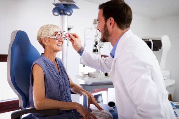 A woman getting an eye exam by her optometrist.