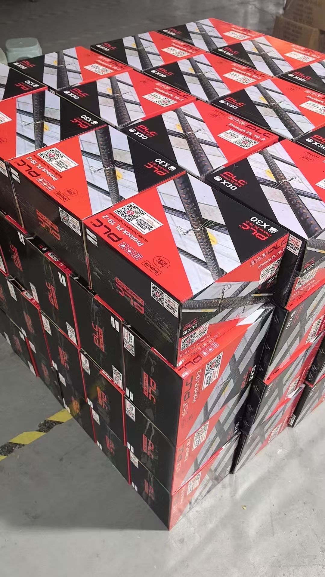 Cardboard box filled with red and black product boxes.