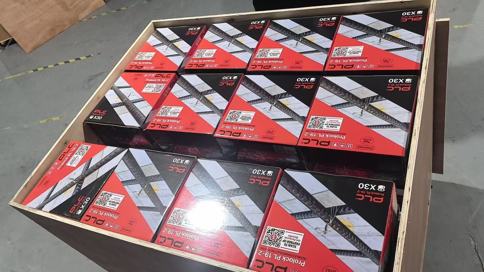 Cardboard box filled with red and black product boxes.