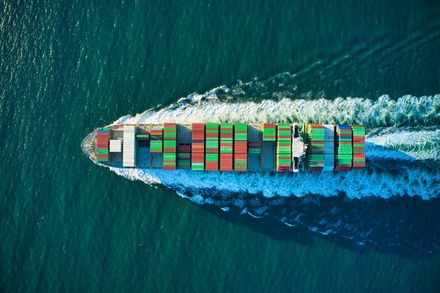 An aerial view of a large container ship floating on top of a body of water.