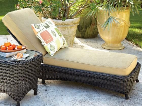 A wicker chaise lounge with a pillow on it