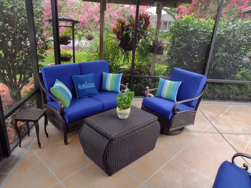 A screened in porch with blue furniture and a coffee table
