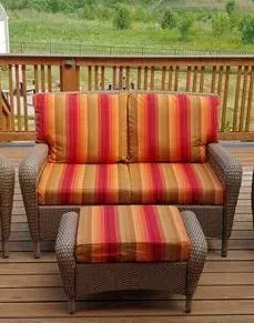 There is a couch and ottoman on the deck.