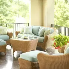 A balcony with wicker furniture and a couch.