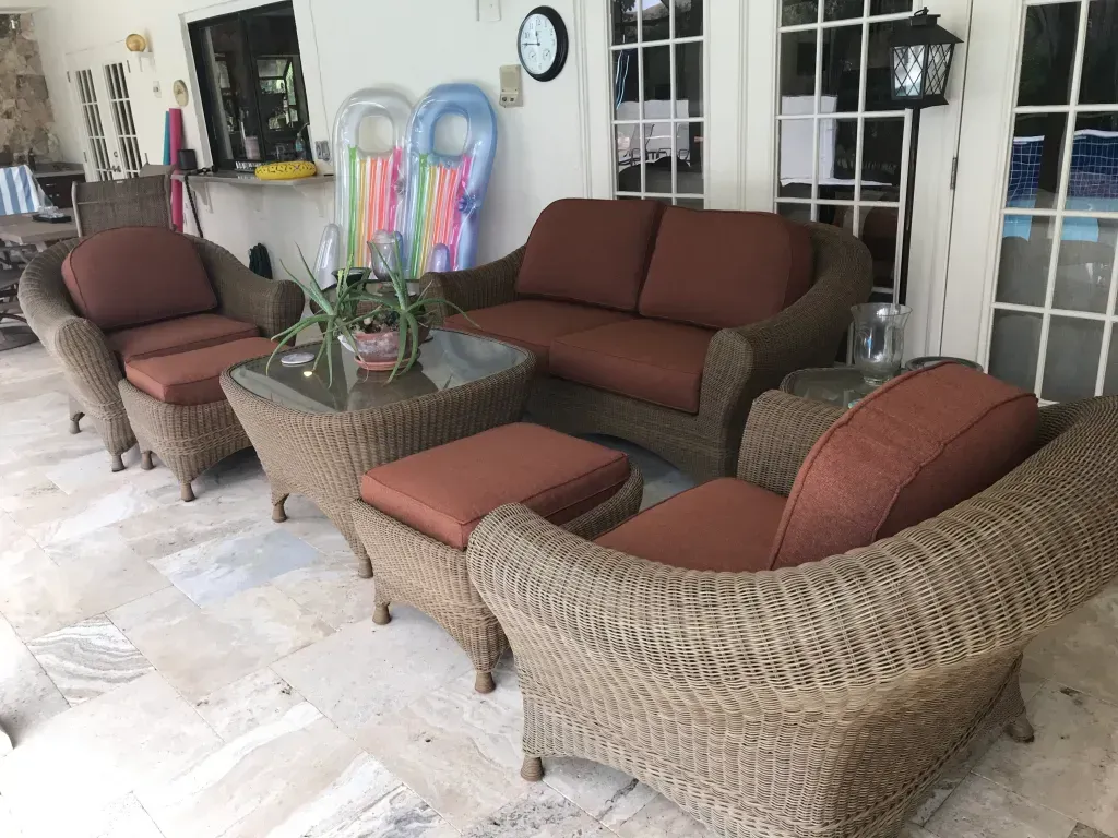 A patio with wicker furniture and a couch.