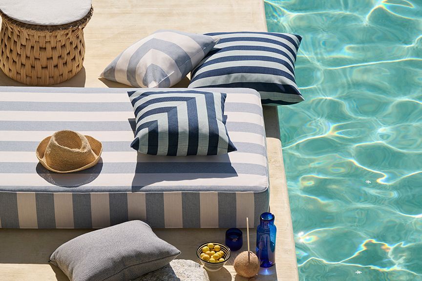A patio with a lot of furniture and a potted plant.
