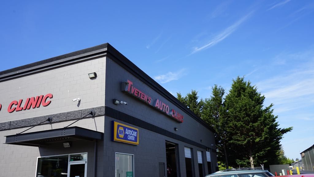 A car is parked in front of a building that says auto clinic.