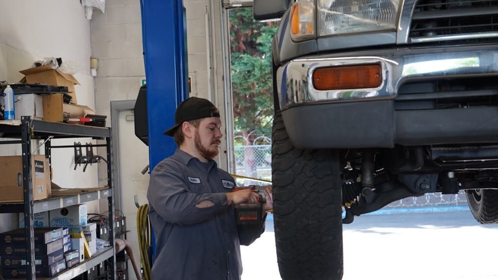 A man is working on a truck in a garage.