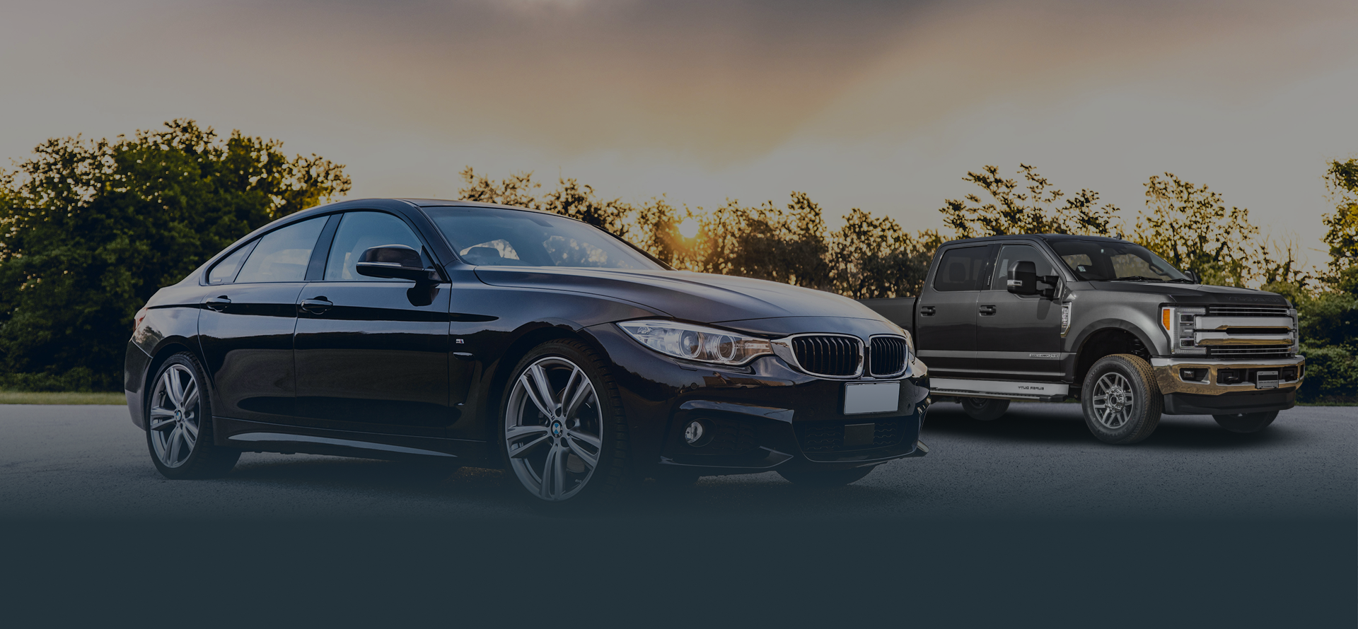 Black car and Black truck parked outside with tree and sun in background | Tveten's Auto Clinic