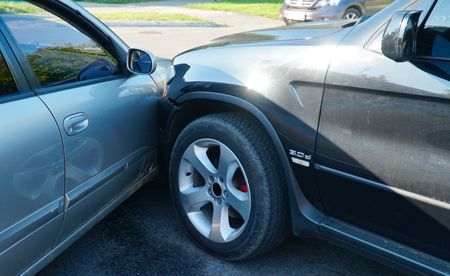 Hands in red gloves working on a car engine.