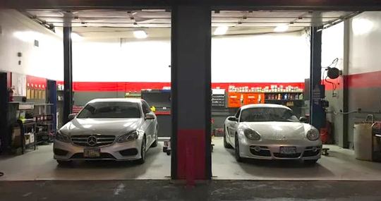 Two cars parked in separate garage bays.