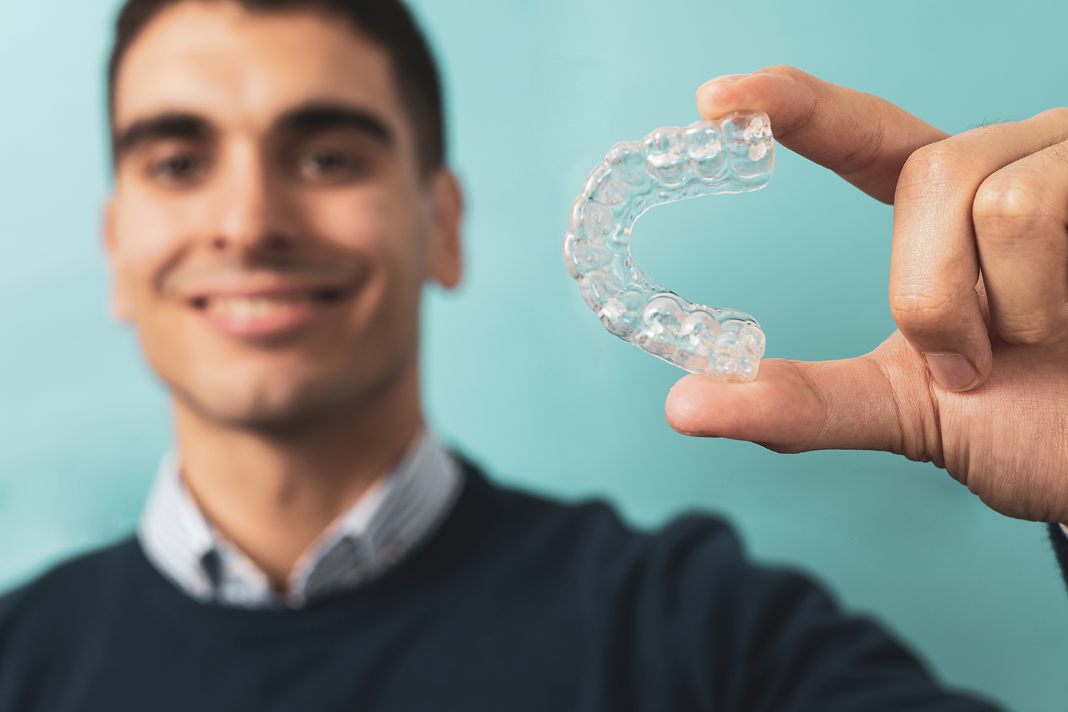 man holding Invisalign clear braces