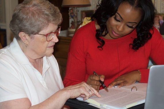 Group of six people posing; some in scrubs, smiling, in a medical office setting.