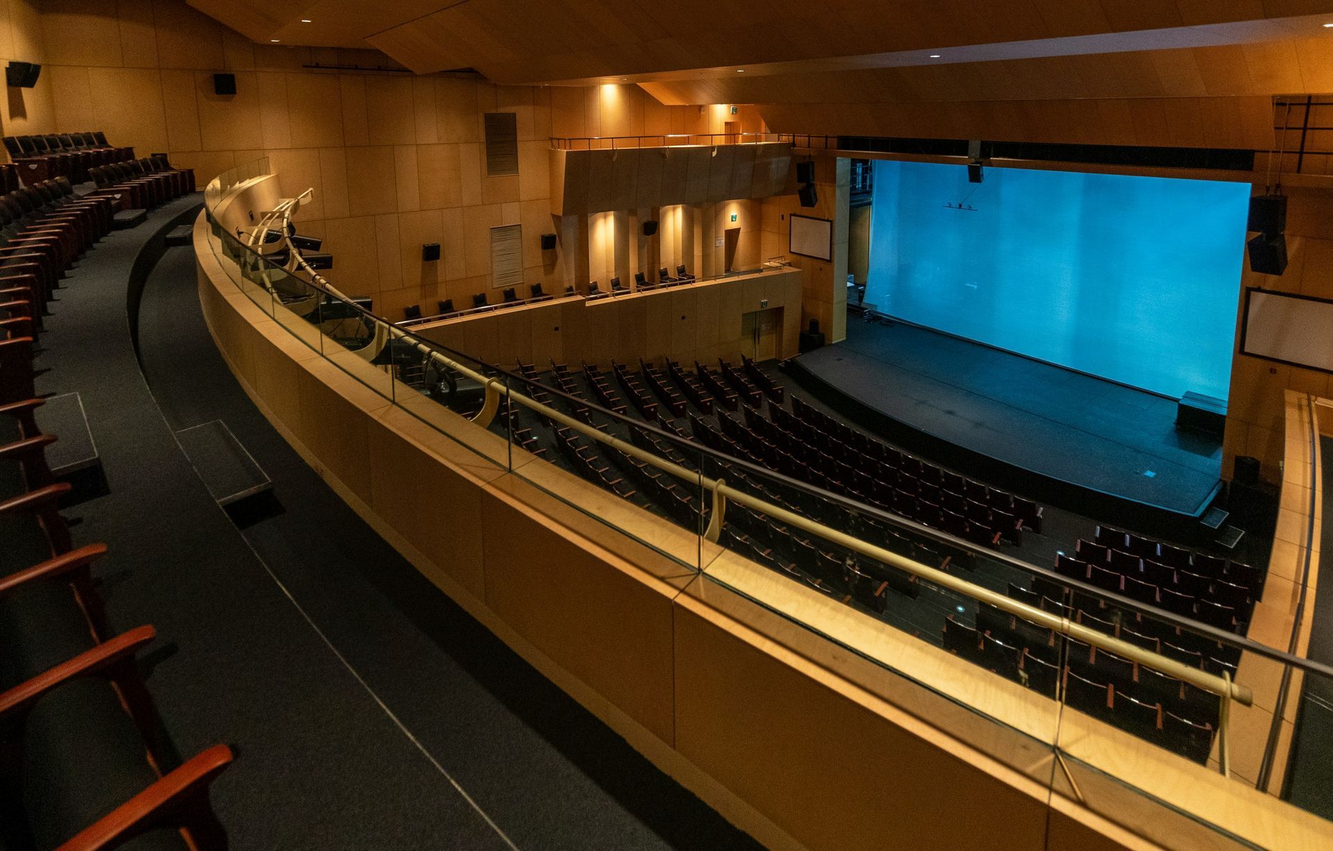 Empty classroom with rows of desks, windows, and natural light streaming in.