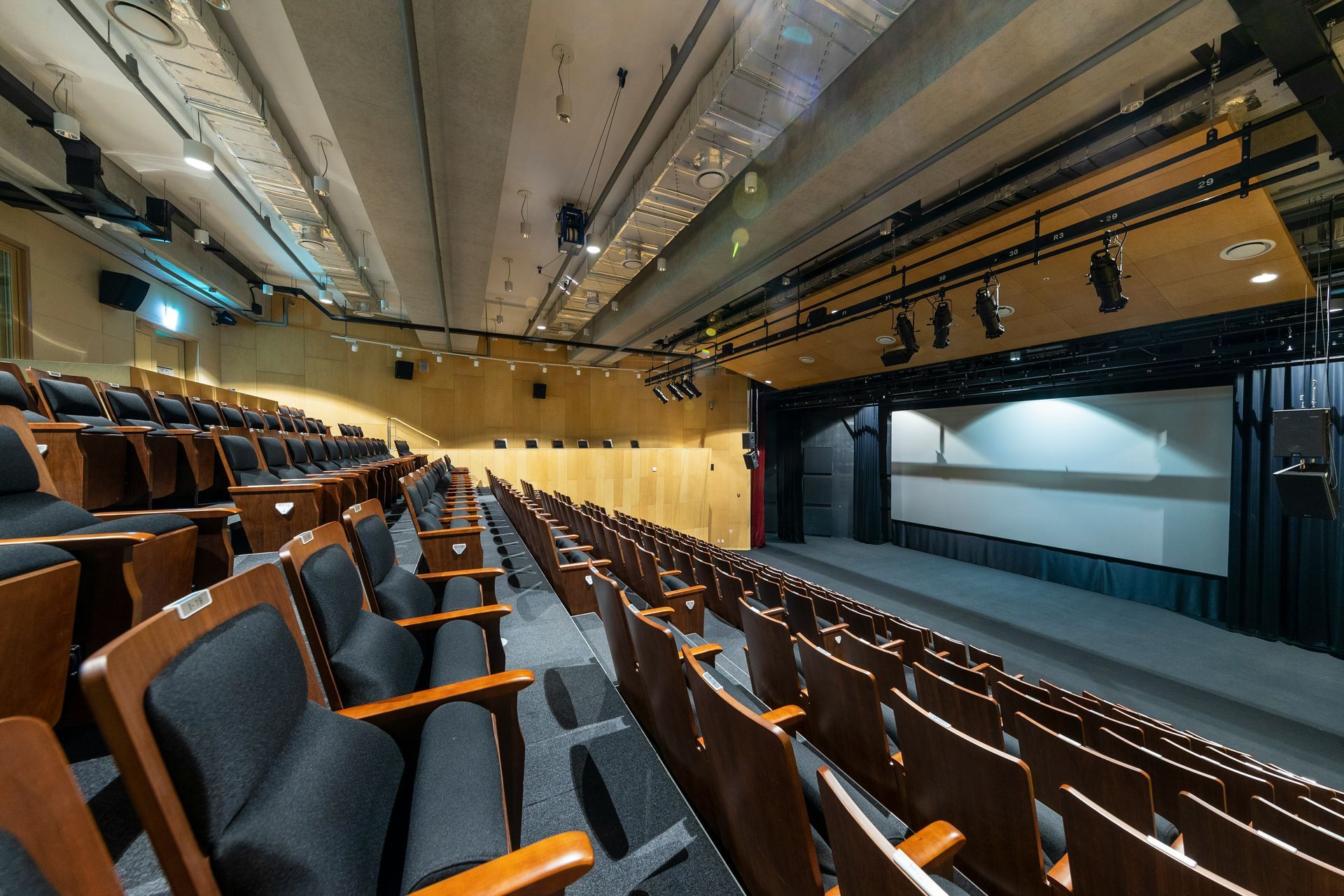 Rows of empty chairs face a stage in a large, empty conference room.