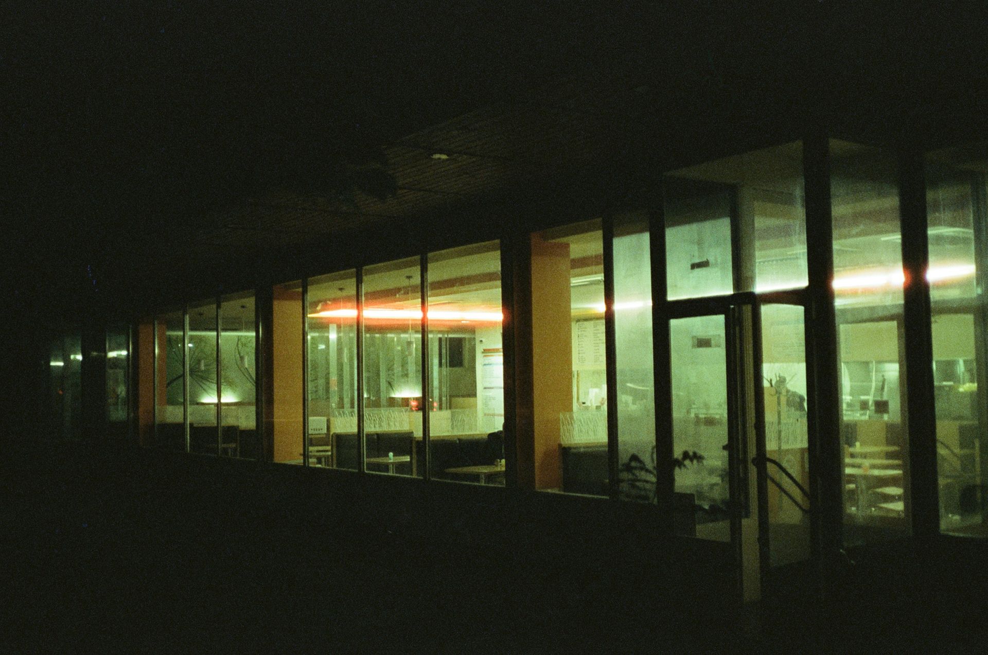 Bank teller booths with brass rails and globe lamps, interior shot.