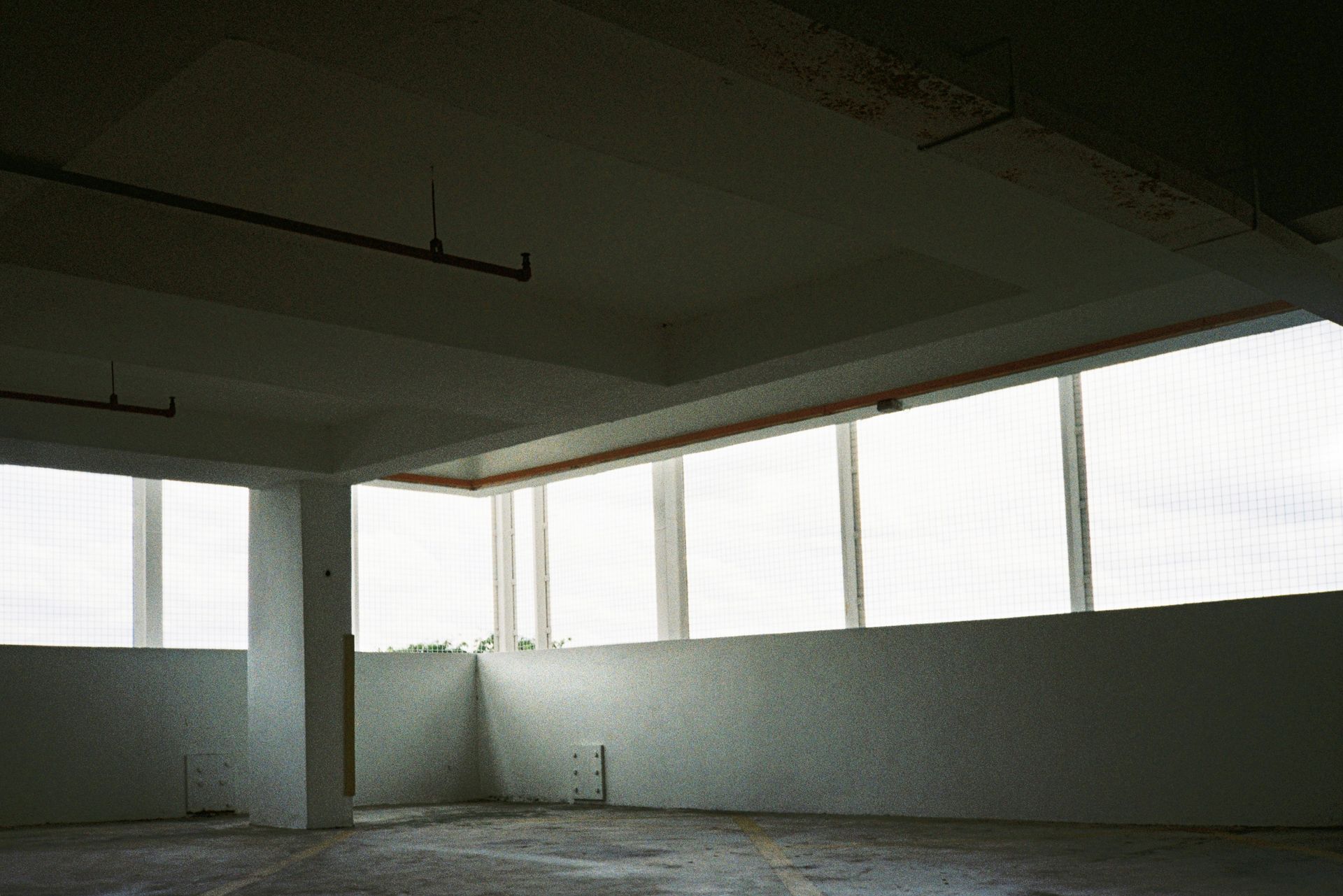 Empty modern bedroom with beige walls, marble floor, and recessed ceiling lighting.