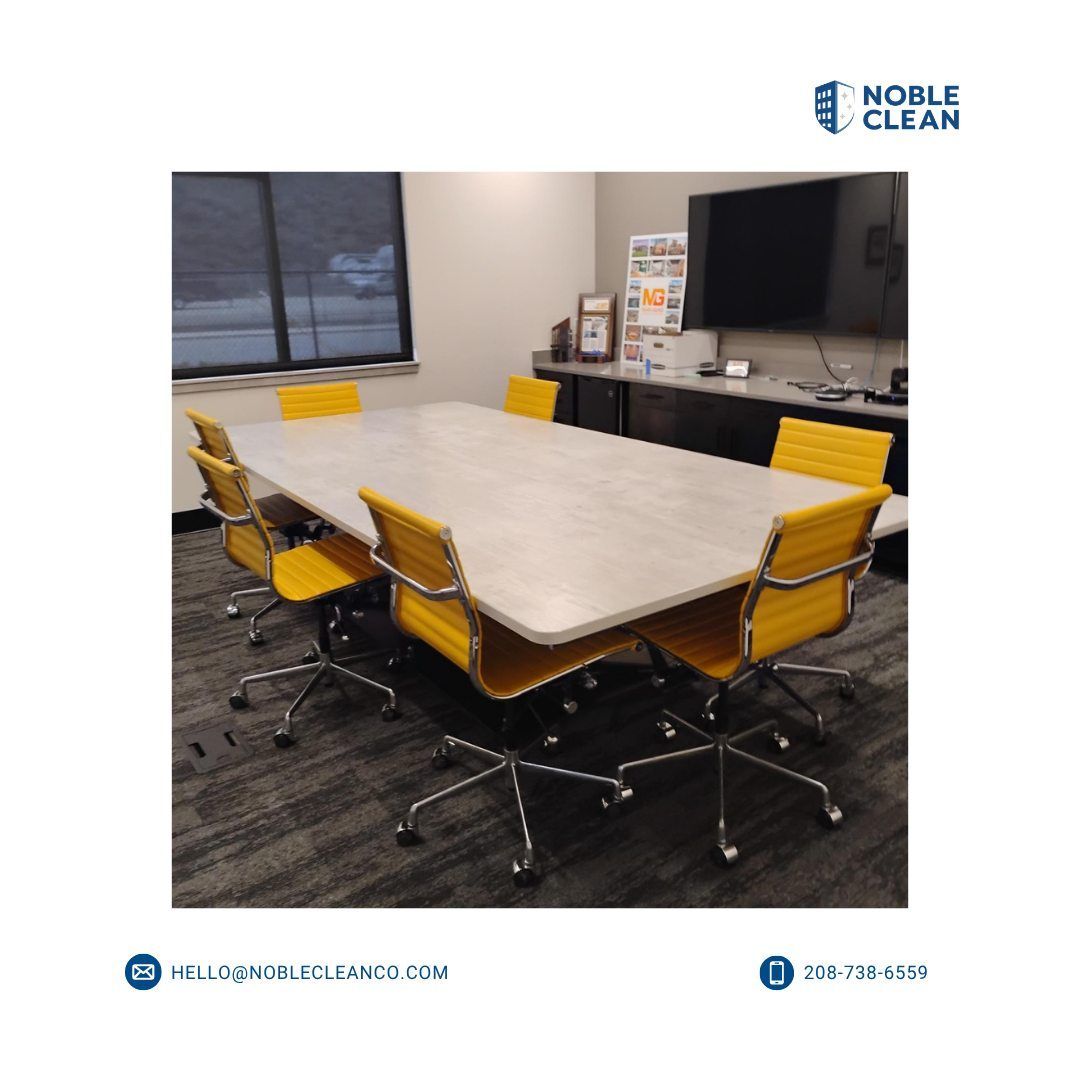 A clean, modern office conference room featuring a large rectangular table surrounded by six vibrant yellow chairs.