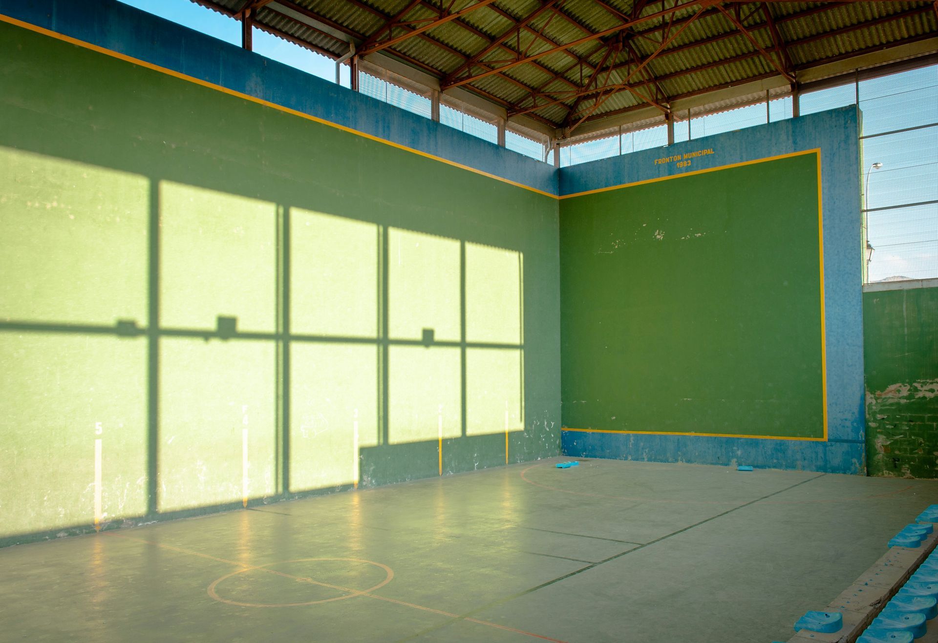 Indoor handball court with green walls and a concrete floor.
