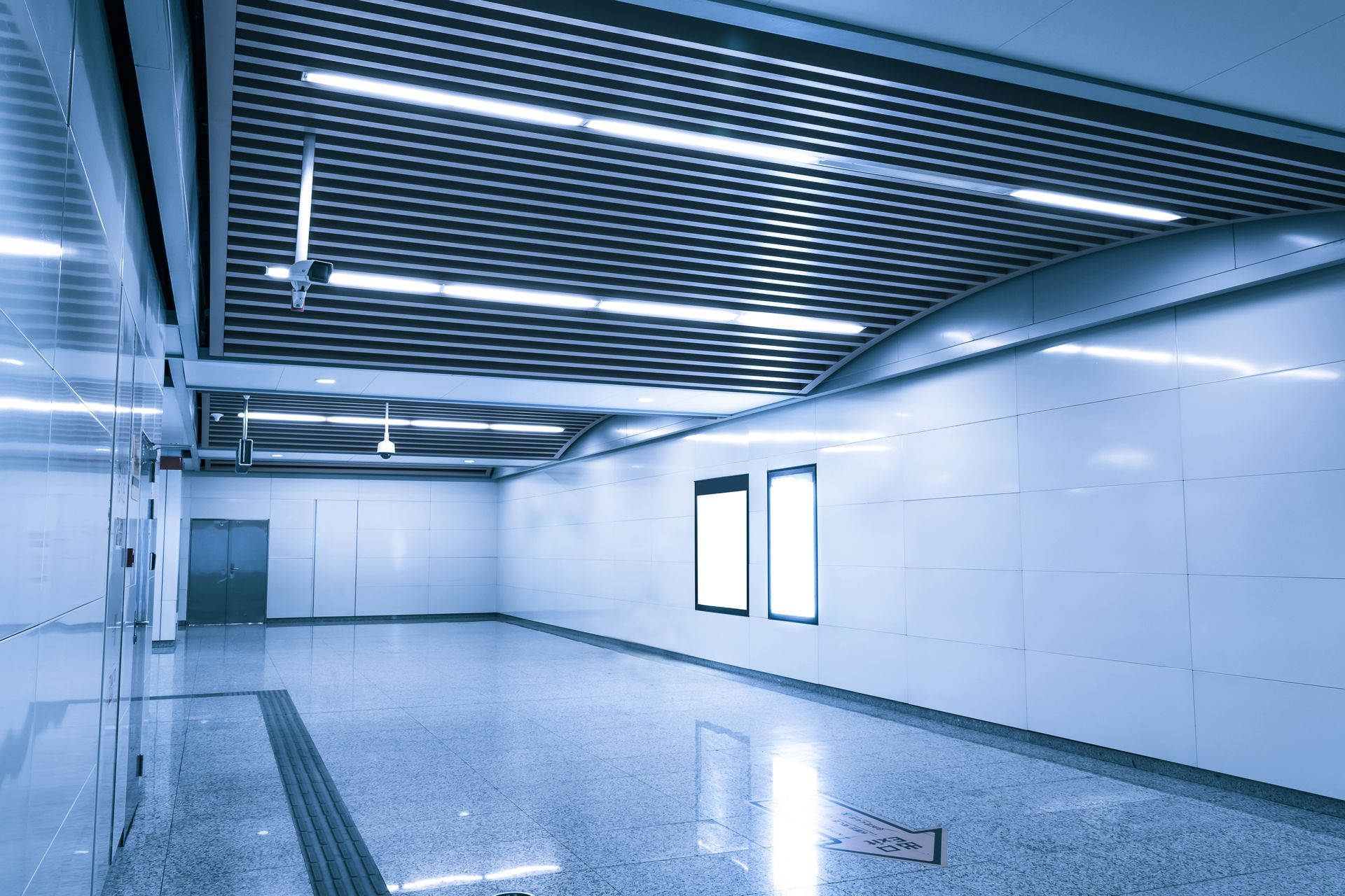 Subway station hallway, modern design, with blank illuminated advertising panels.