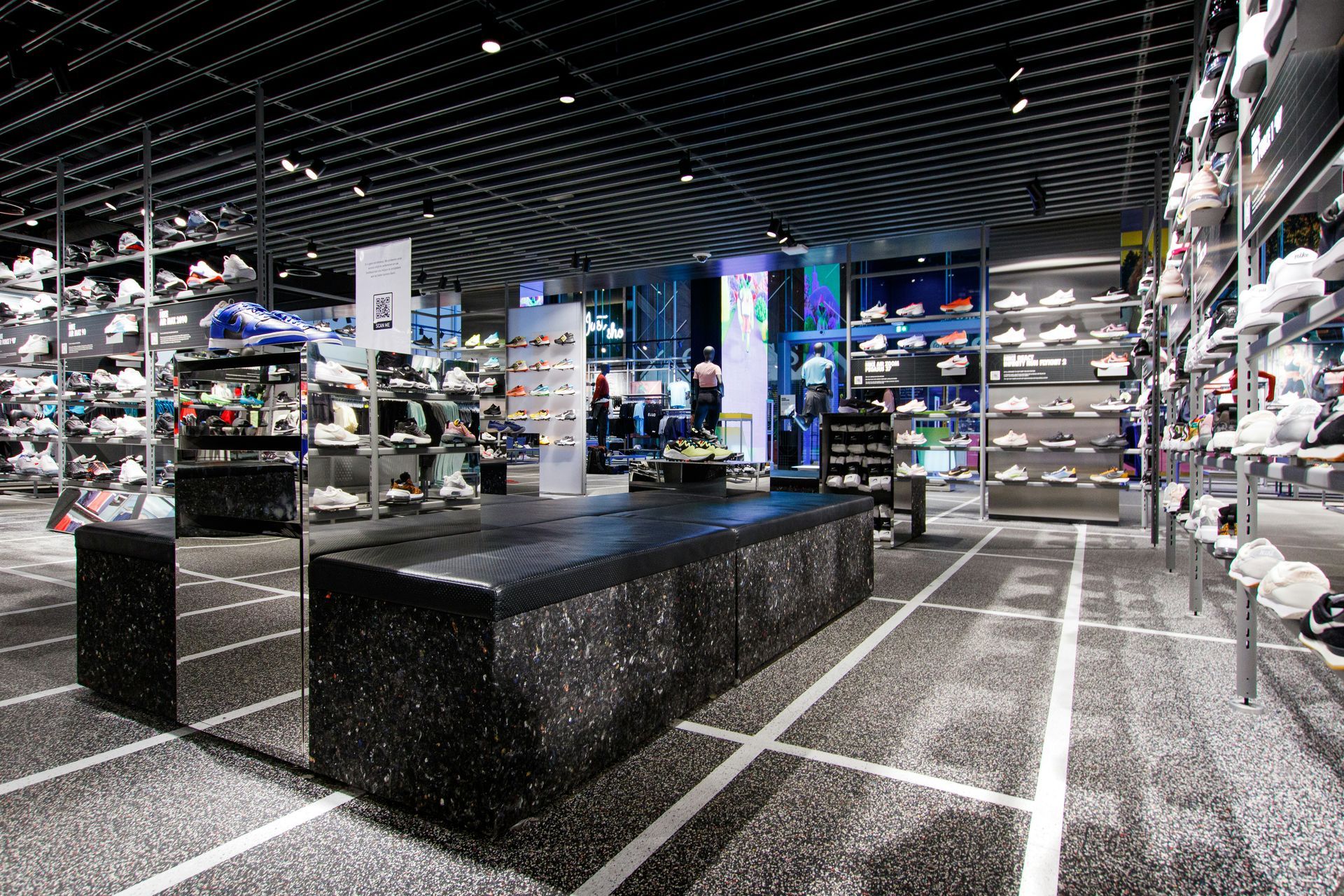 Shoe store interior with many sneakers on display; black and white color scheme.