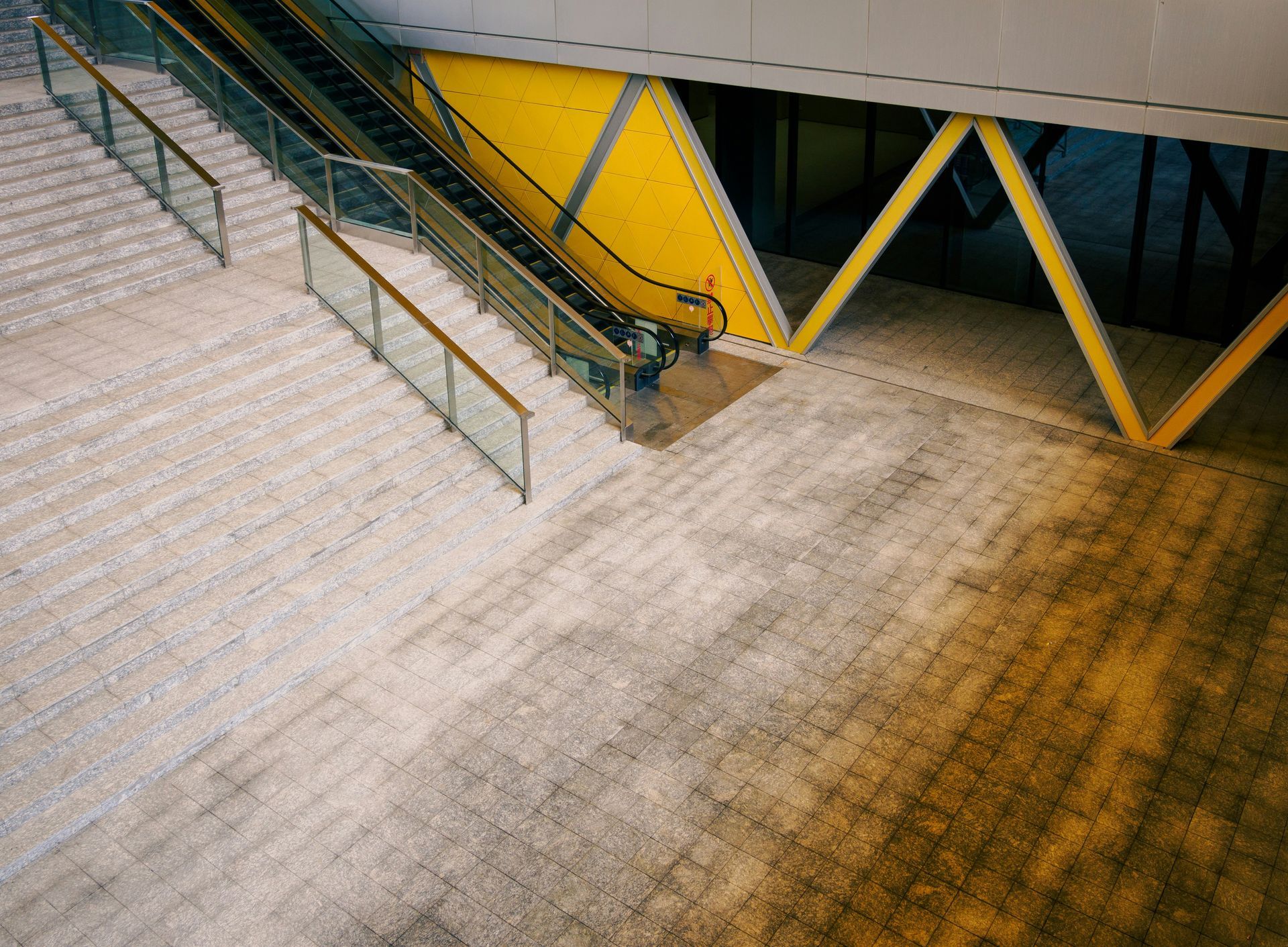 Empty modern bedroom with beige walls, marble floor, and recessed ceiling lighting.