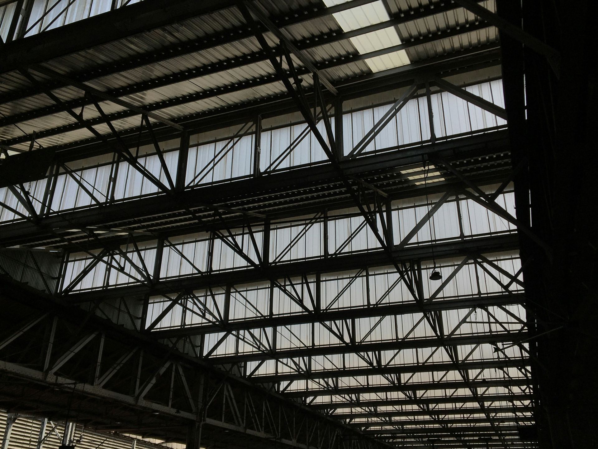 Steel beams and skylights in a high industrial ceiling; interior shot.