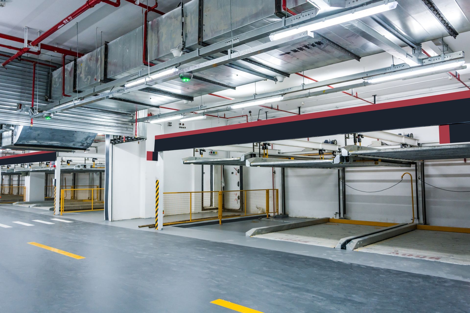 White industrial crane on tracks inside a building with a glossy floor and white railings.