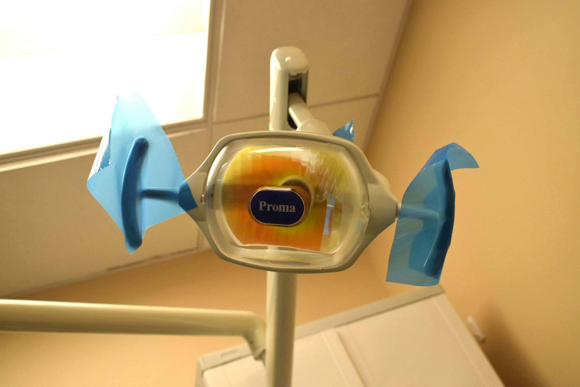 Dental light with blue shields, angled toward the viewer in a dentist's office.