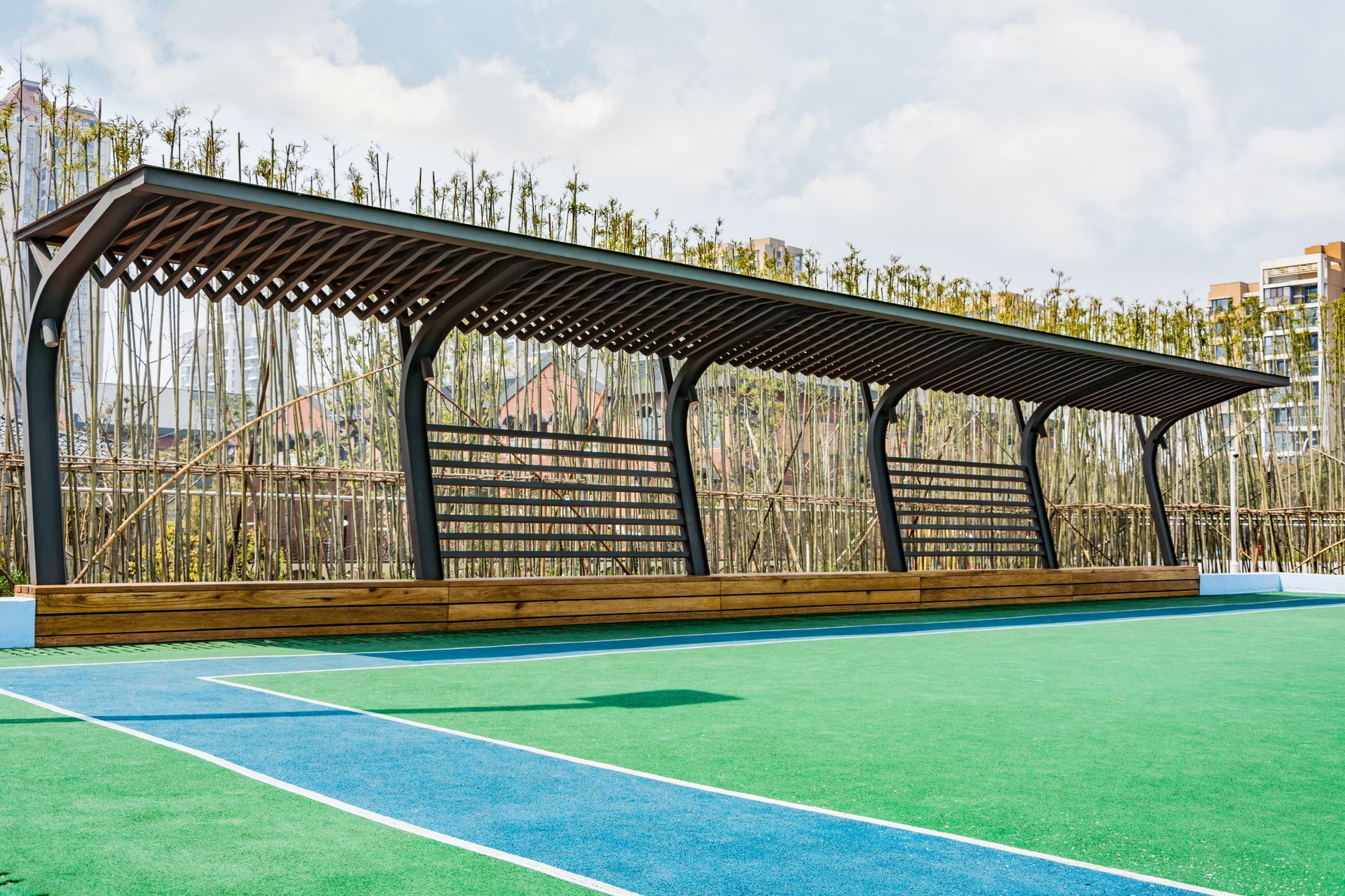 Covered outdoor seating area with a green and blue ground.