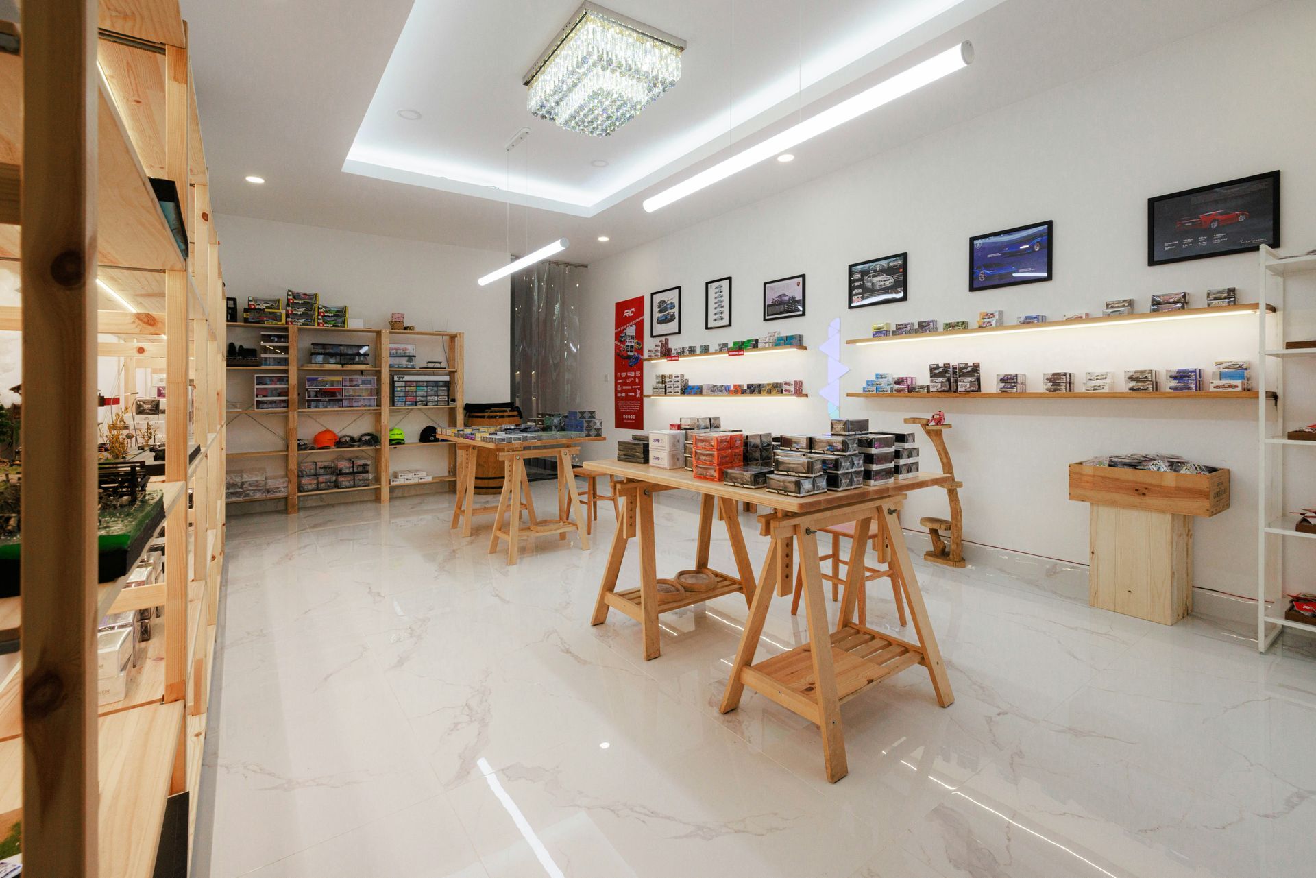 Toy store interior with wooden shelves, tables, and various model vehicles displayed.