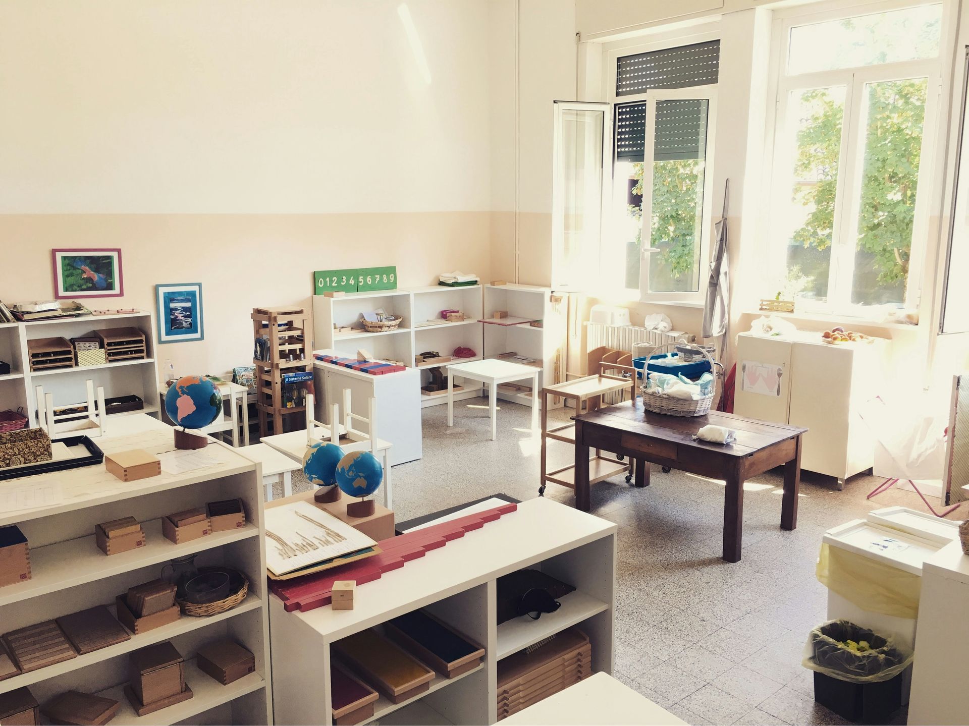 A bright medical office with white shelves, toys, and sunlight from a large window.