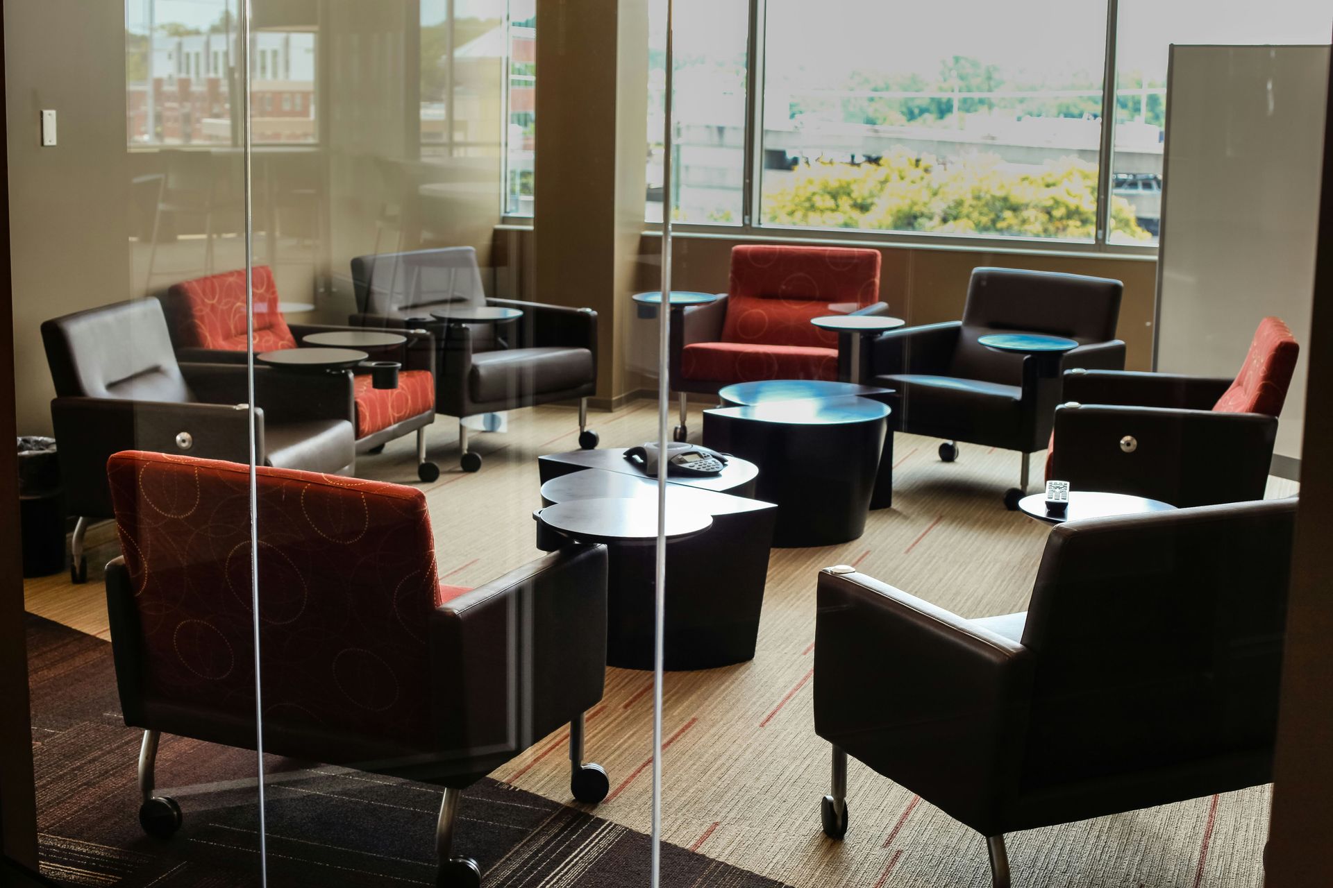 Office waiting area with chairs arranged in a circle; neutral colors and large windows.