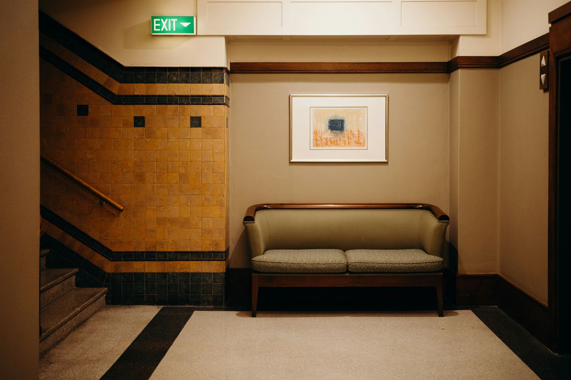 Hallway with a small couch, artwork, and an