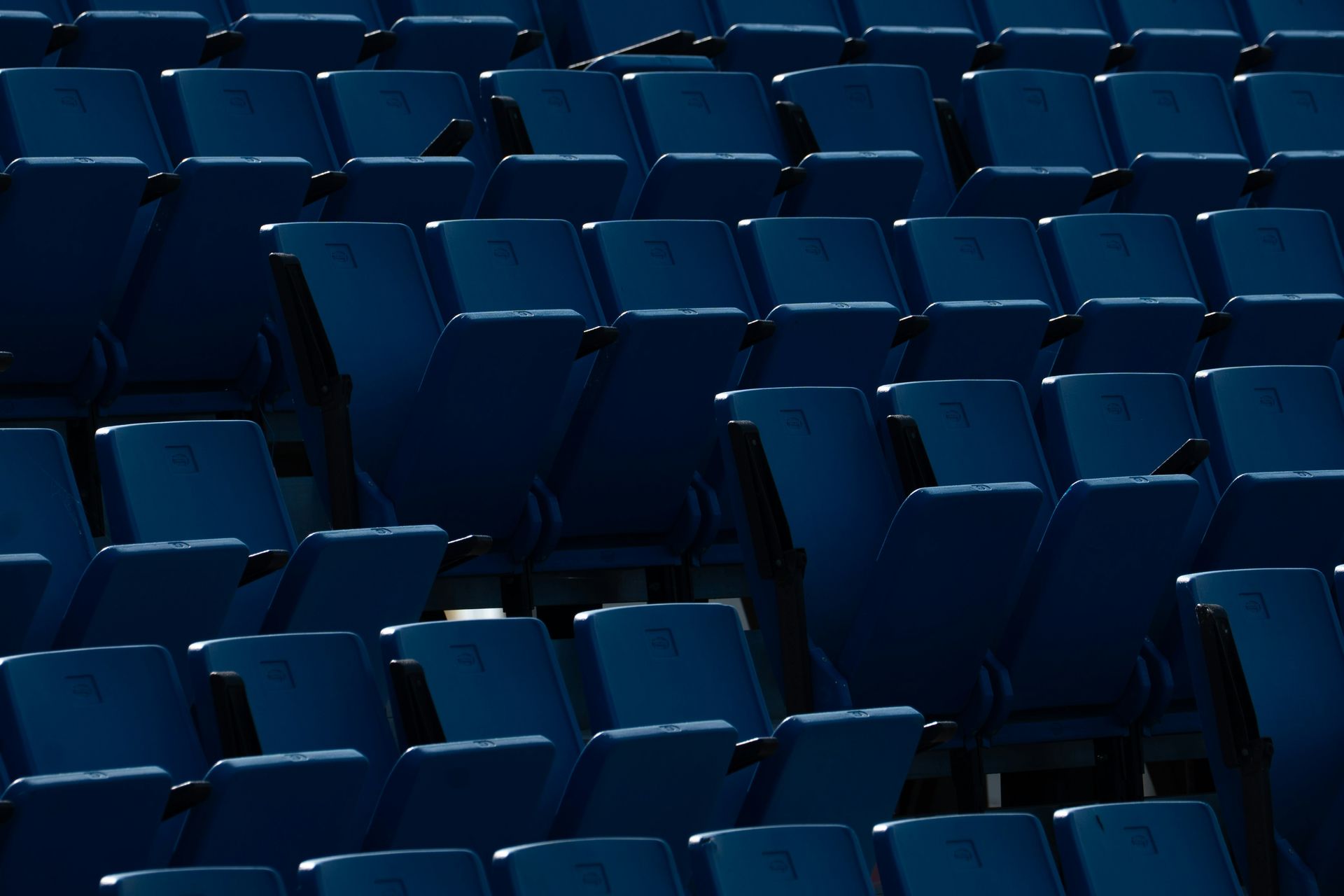Rows of empty blue stadium seats.