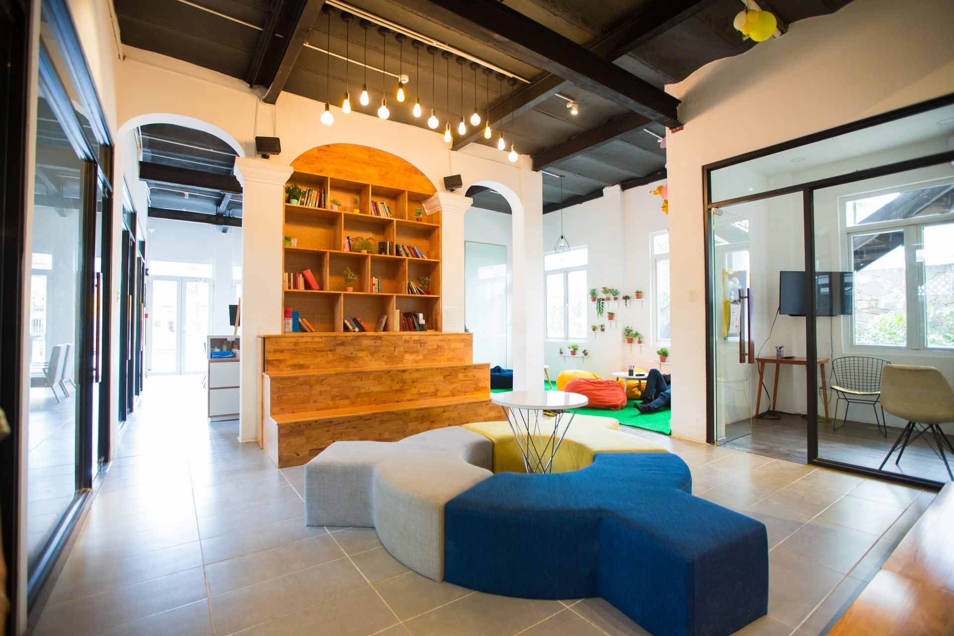 Waiting room with metal chairs, off-white walls, and doors. A wheelchair and air conditioner are visible.